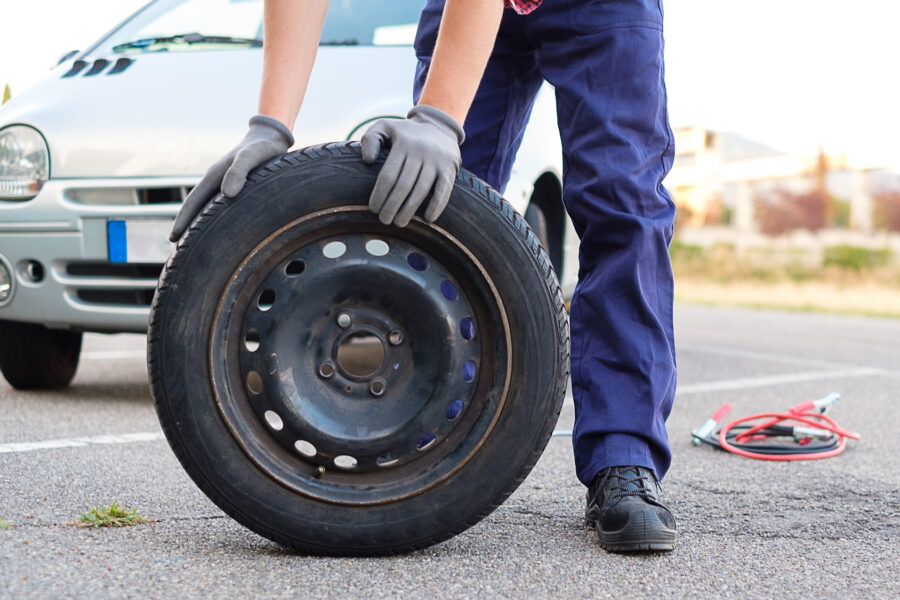 Man changing a flat tyre after vehicle breakdown