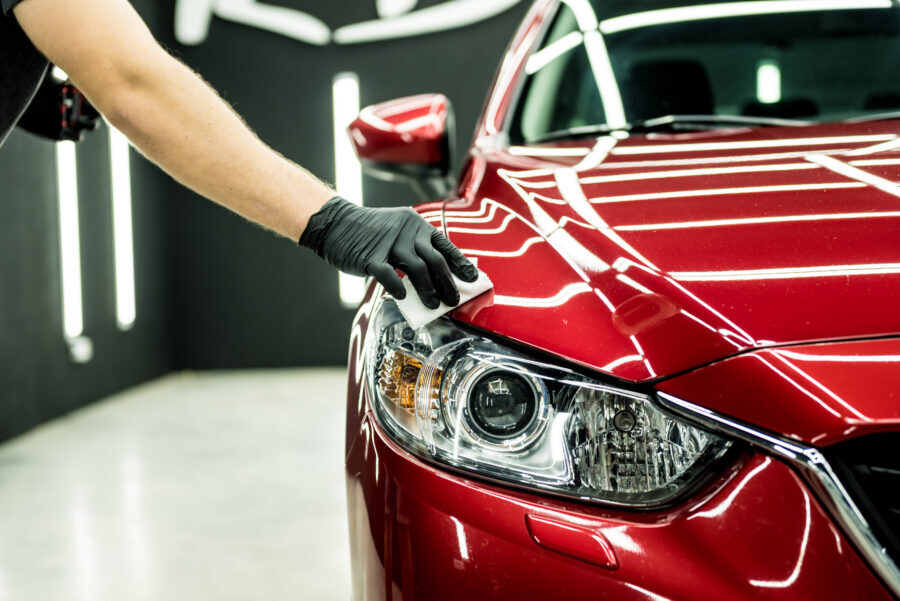 Car service worker applying nano coating on a car detail.