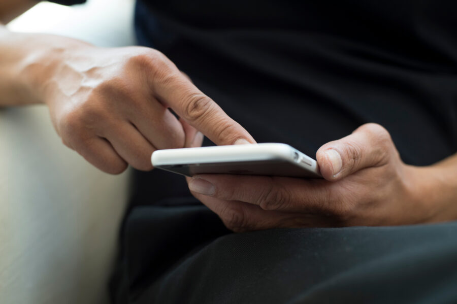 The hands of the men who are using a smartphone